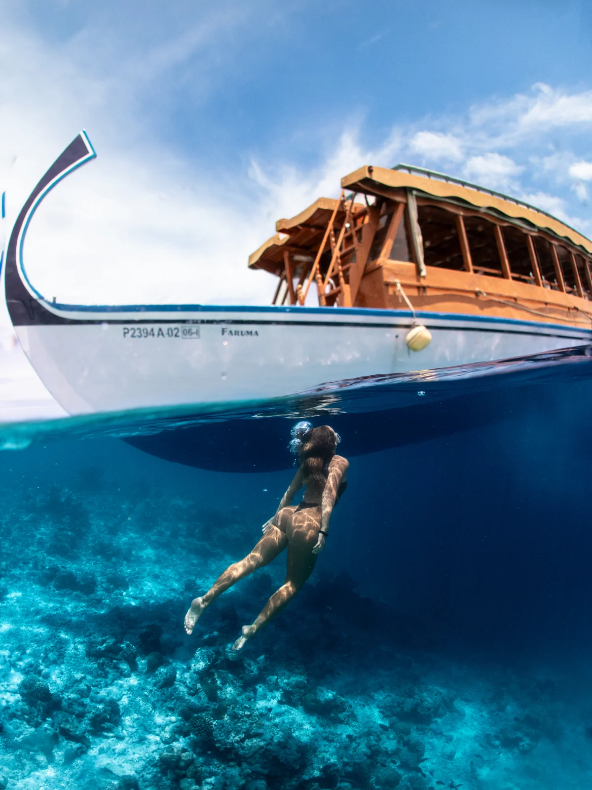Barca e nuotatore nelle acque delle Maldive